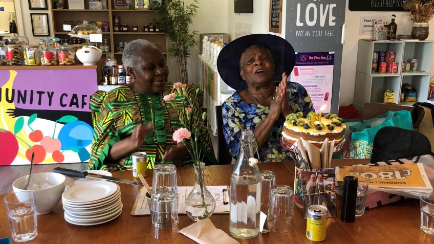 Two women seated at a table with cake